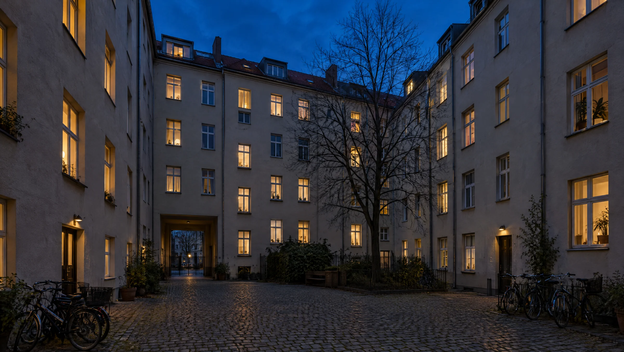 Berliner Hinterhof zur Blauen Stunde mit erleuchteten Fenstern und Fahrrädern